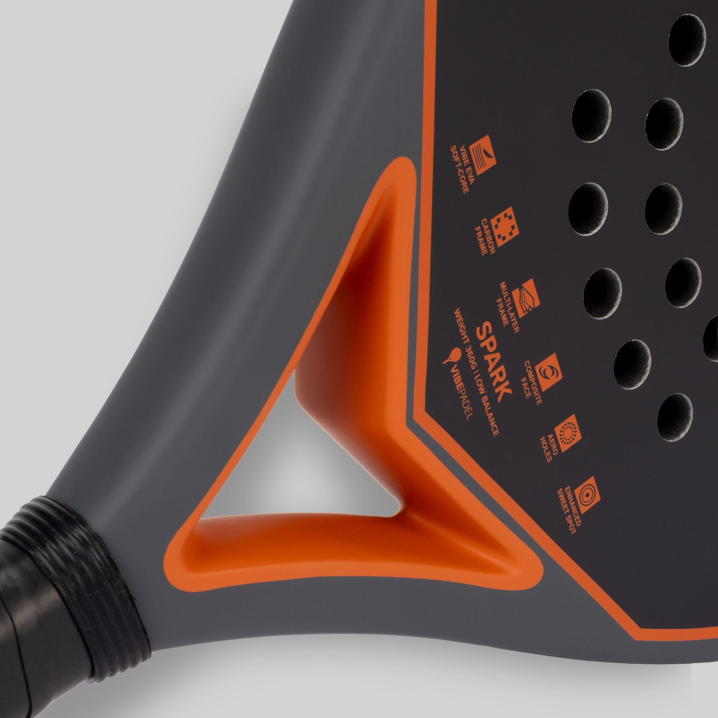 Close-up of a grey and orange spark padel racket on a white background